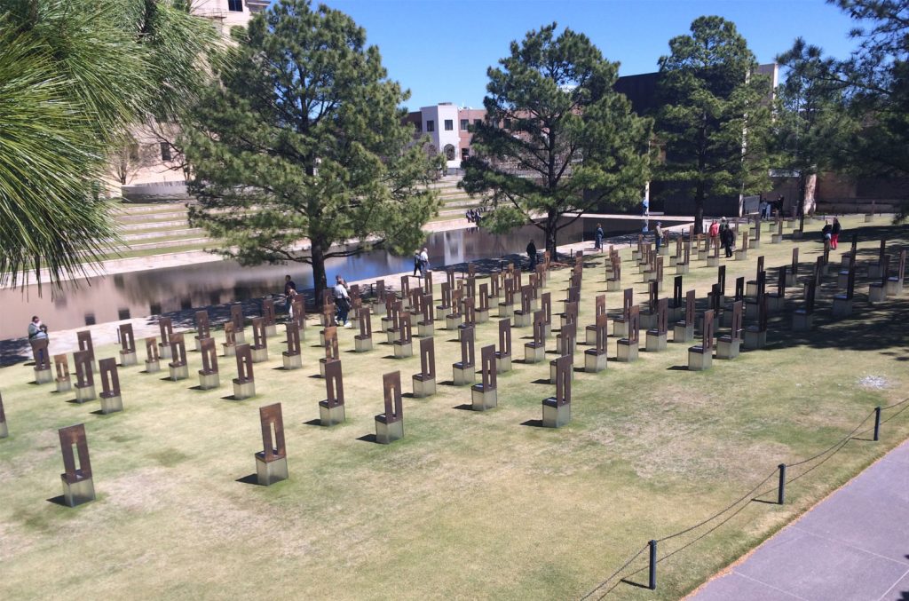 The chair-like memorials for the victims sit on the site of the Murrah building. The pond in the foreground now sits where the road was located.